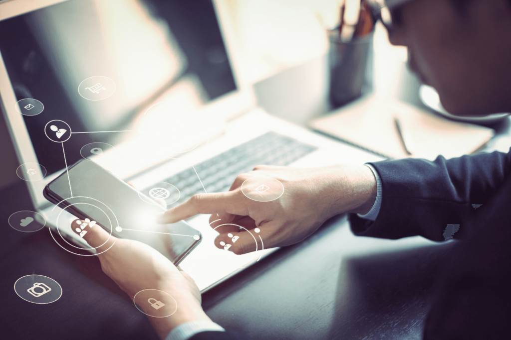 Businessman hand working with mobile phone and laptop computer with technology digital graphic